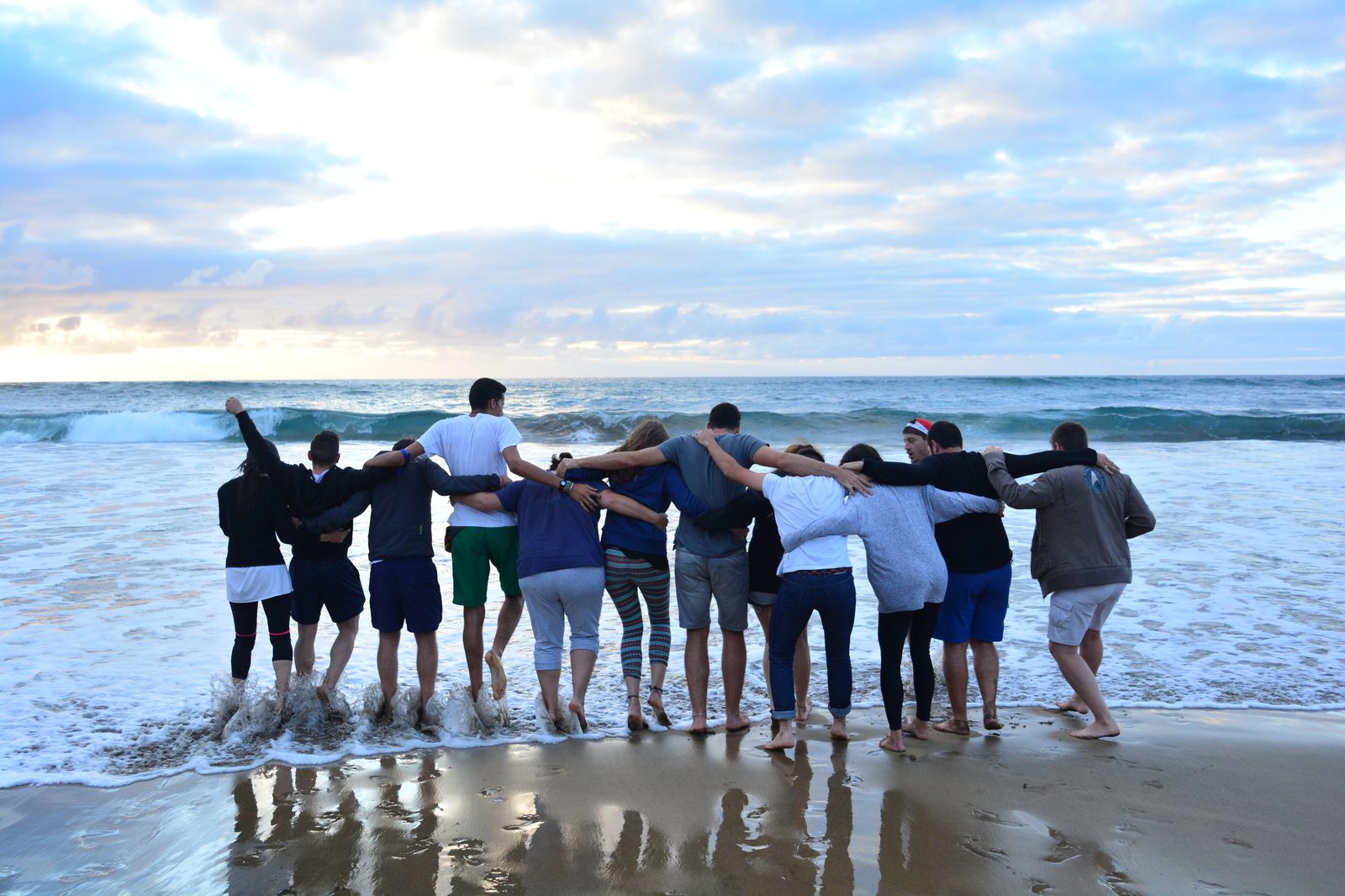 Grupo de amigos abrazados en la playa