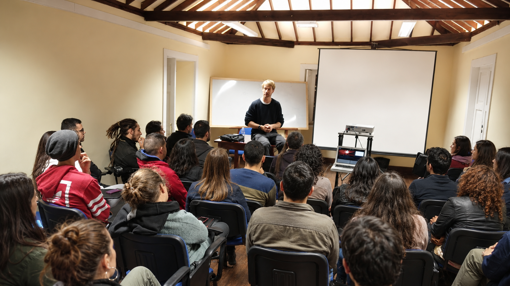 Juan Serantes dando una clase a un grupo de estudiantes en un aula