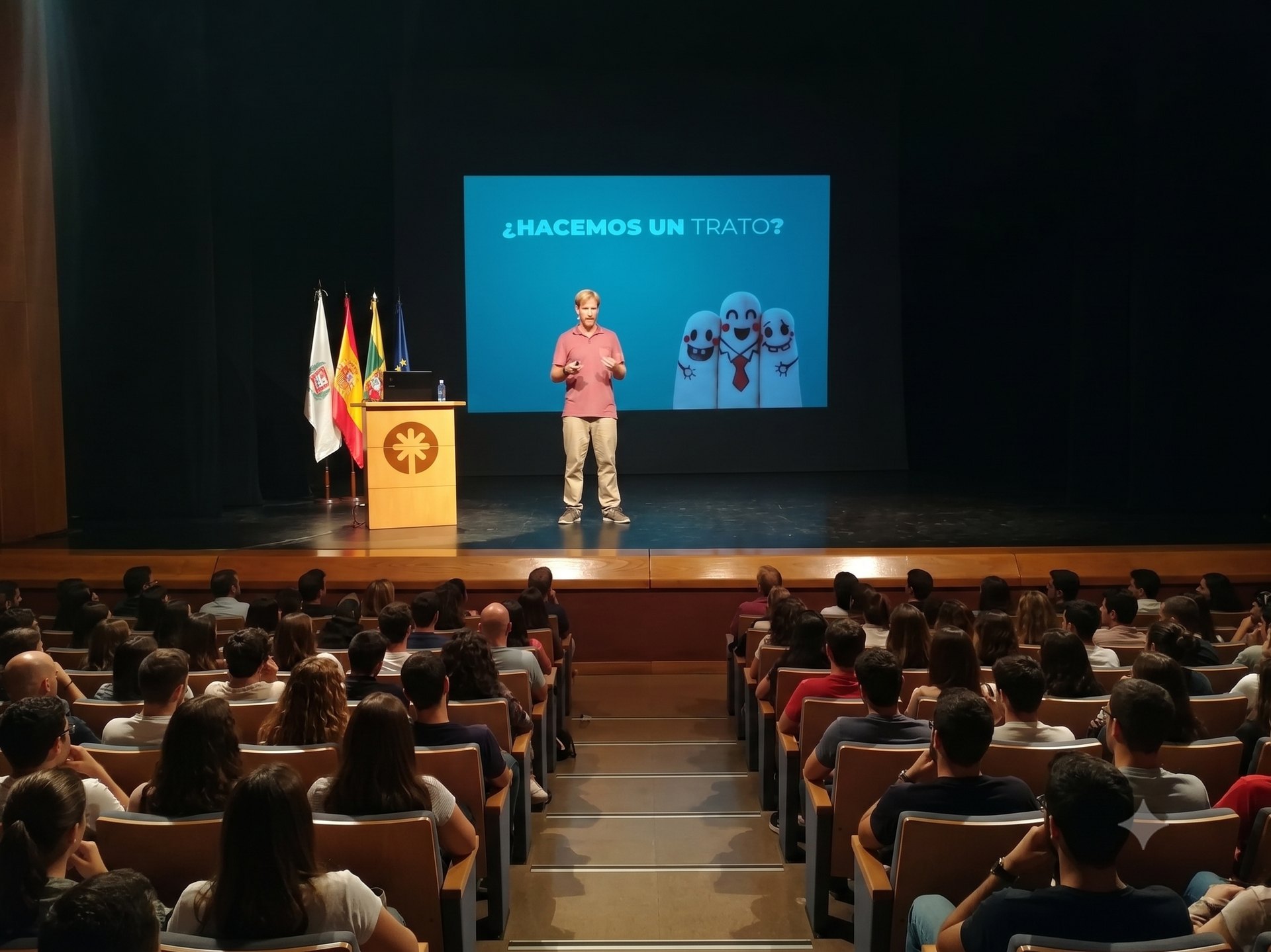 Juan Serantes dando una charla ante un grupo en un teatro