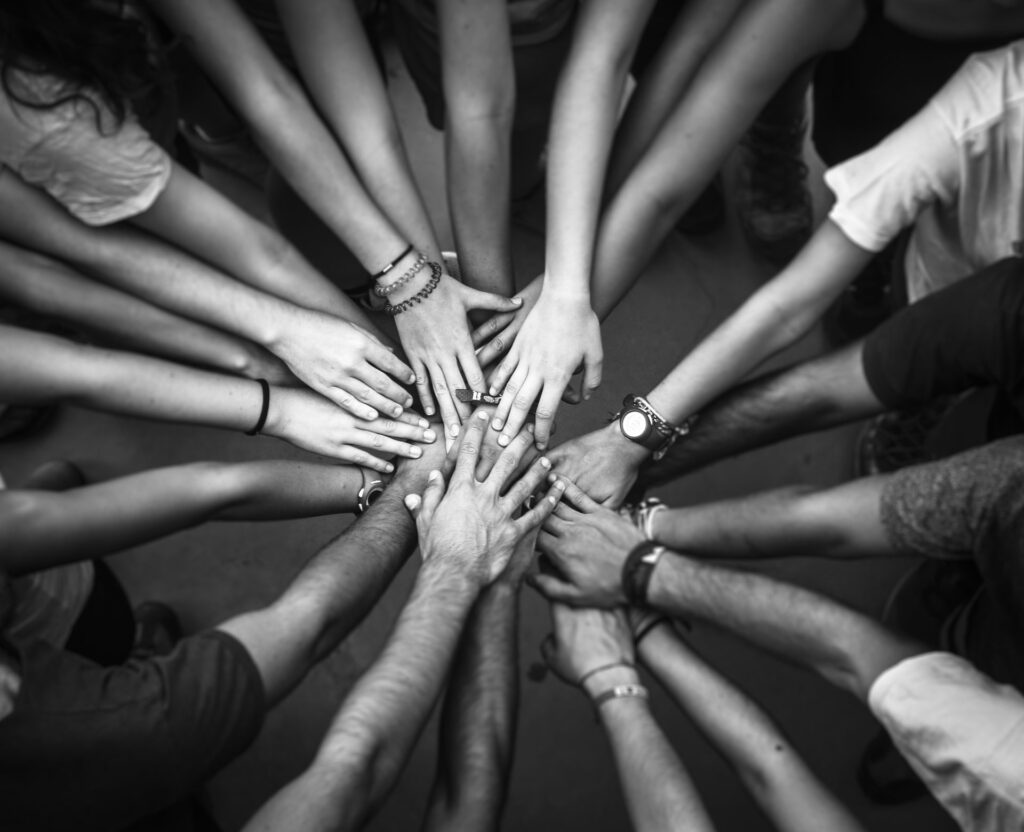 Manos de un grupo unidas en el centro de un círculo
